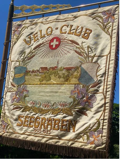 Fahne von 1925 des 1905 gegründeten Velo-Clubs Seegräben mit dem Zürcher Wappen und dem Seegräbner Wappen, das einen gelben Einbaum auf blauem Untergrund zeigt.